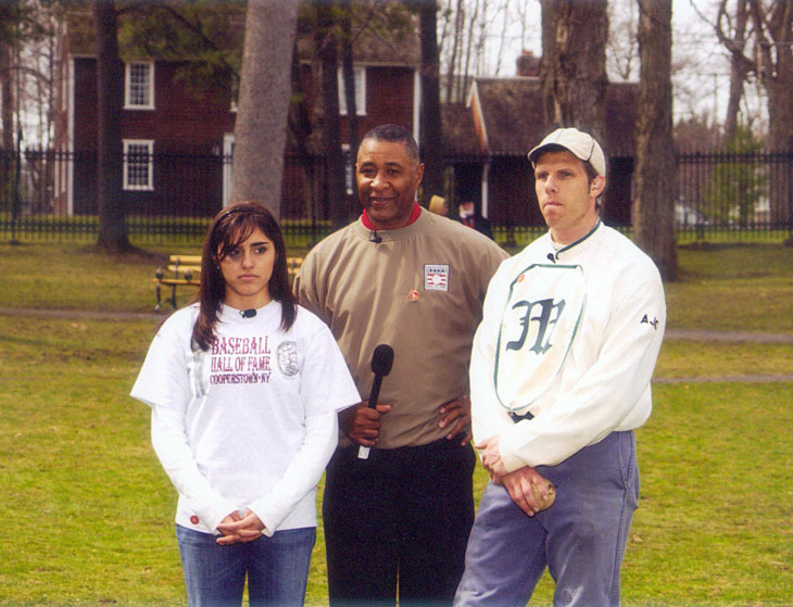 April 26, 2005 - Cooper Park, Cooperstown, NY.  Tuyaymya Osuna, student from San Diego, CA, Hall of Fame baseball player Ozzie Smith and Eric Miklich, 19c Base Ball, NY Mutuals and Old Bethpage Village Restoration, shown during a brief time out while filming “Discovering Our American Sprit,” sponsored by Ball State University and the Baseball Hall of Fame.  Both live programs of this Electronic Field Trip were seen by an estimated 17 million grade school students in North America.  Miklich explained and demonstrated the history of the pitcher including the evolution of pitching deliveries from 1860–1887 during both of his eight minute segments. Click photo to return to previous page.